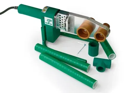 Herramienta de fusión de tuberías de plástico verde con accesorios de cobre y secciones de tubería sobre un fondo blanco.