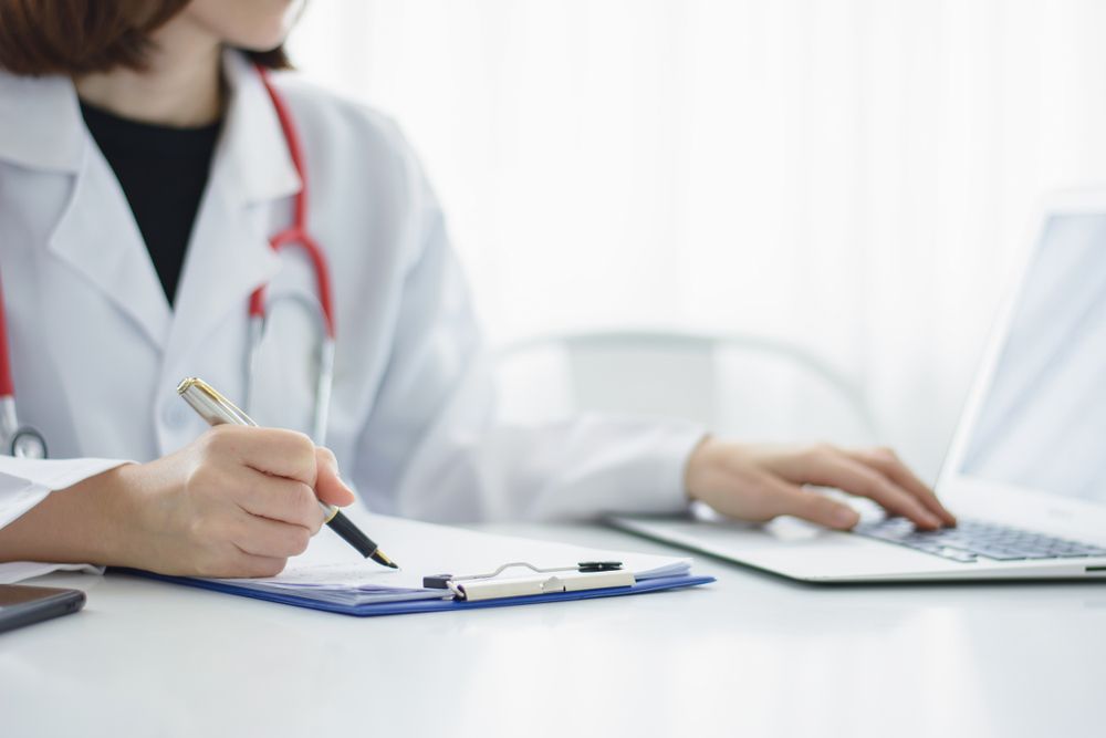 Doctor in White Coat, Red Stethoscope, Writing on Clipboard — DAB Services in Bendigo, QLD