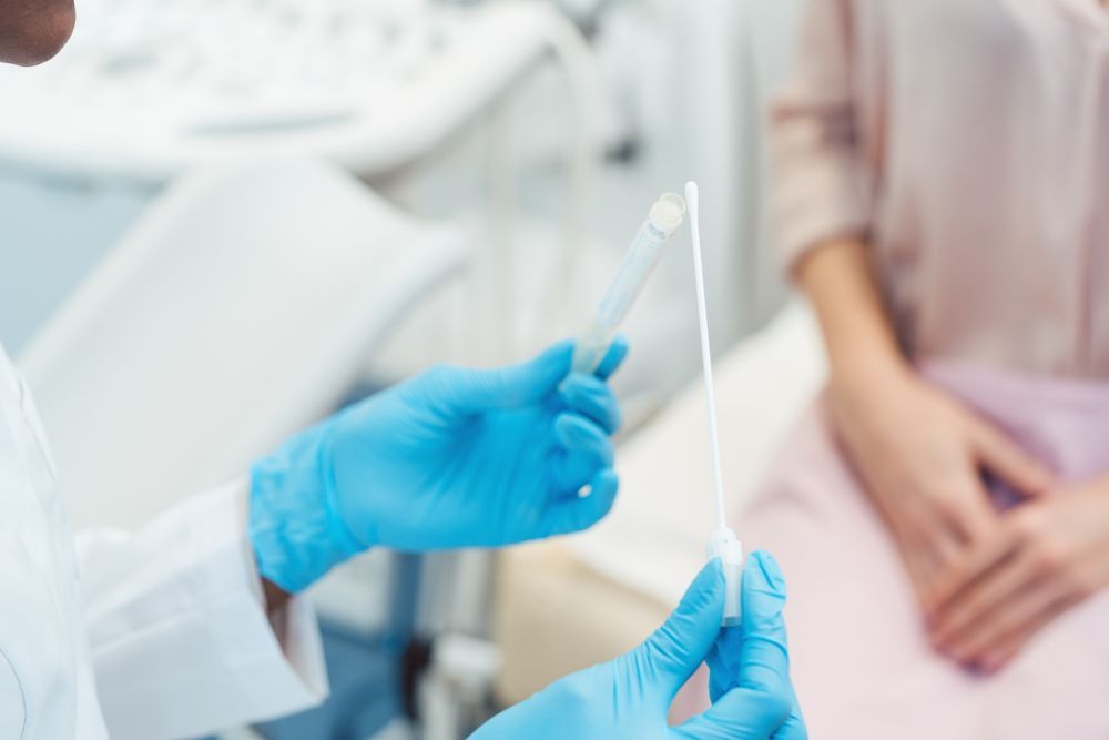 Doctor in Blue Gloves Holding a Swab and Vial — DAB Services in Proserpine, QLD