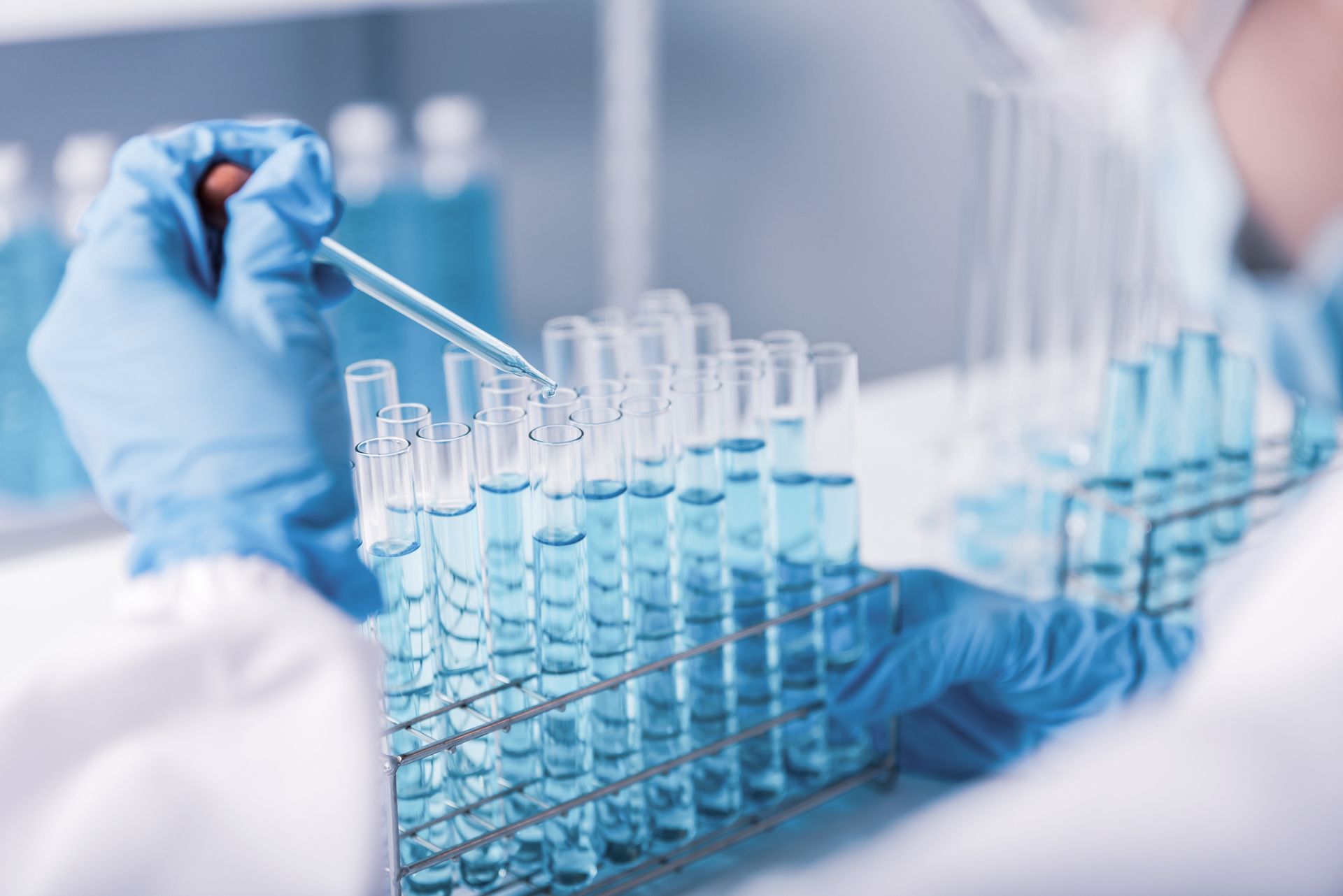 Scientist in Lab Coats and Gloves Using a Pipette — DAB Services in Proserpine, QLD