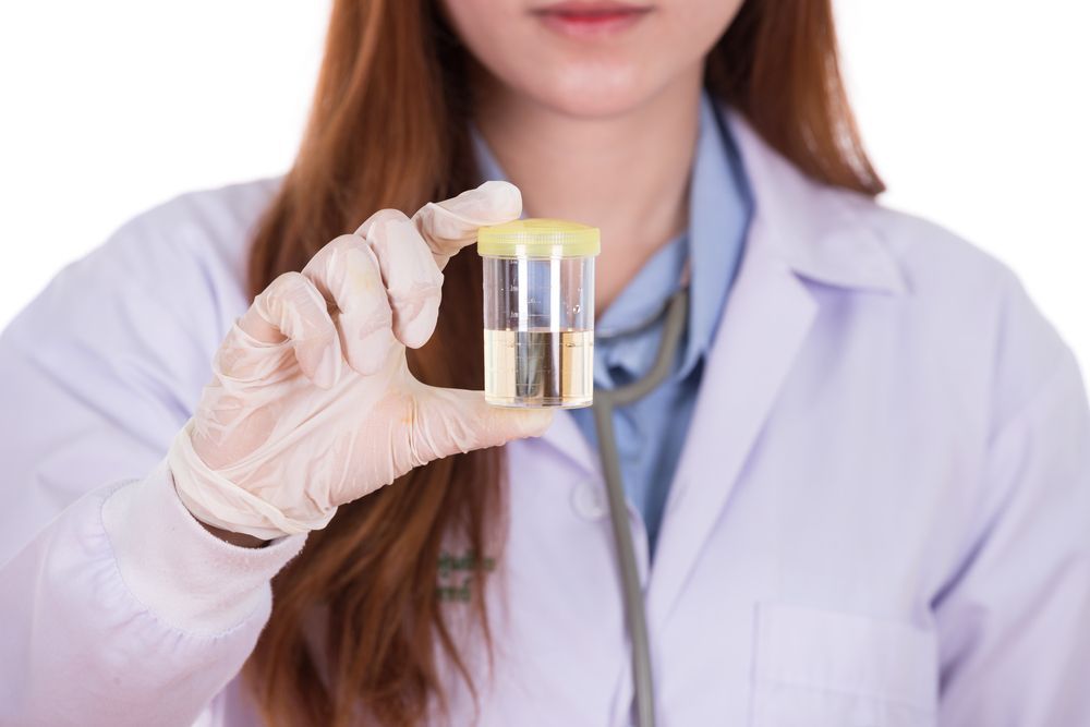 Doctor Holding a Urine Sample, Wearing Gloves and a Lab Coat — DAB Services in Proserpine, QLD