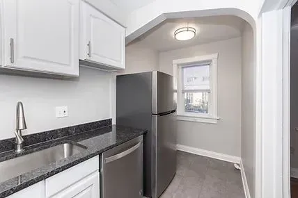 Kitchen with white cabinets, stainless steel appliances, and gray countertops.