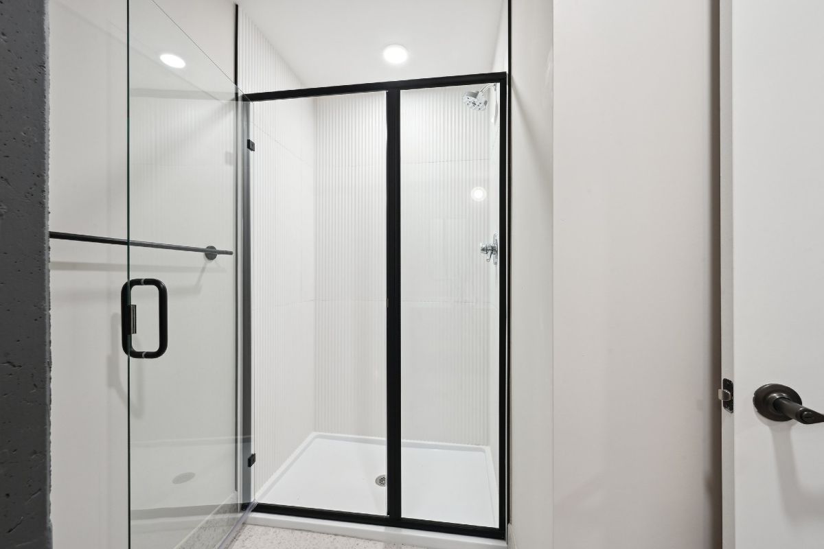 A bathroom with a sliding glass shower door.