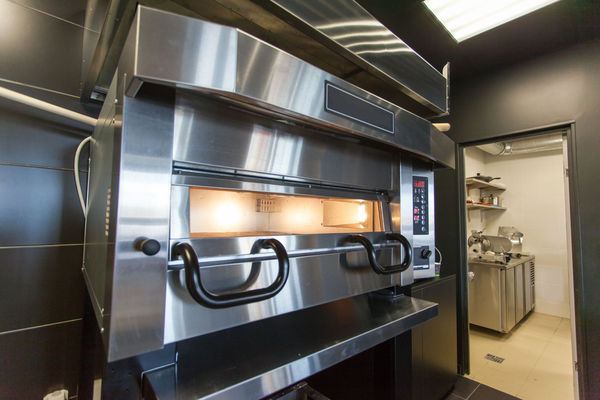 Modern oven baking hot pizza in a restaurant kitchen. Modern oven baking hot pizza in a restaurant kitchen.
