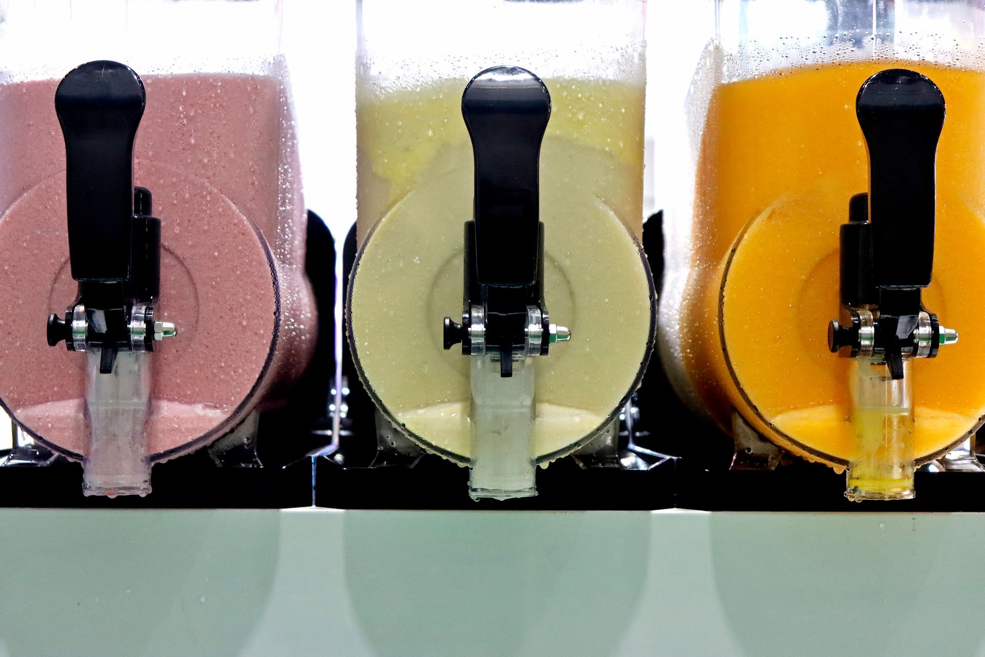 Close-up image of three cold-fruit-smoothie machines.