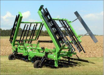 A green and black machine is sitting in a field