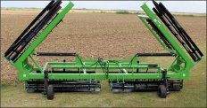 A green tractor is sitting in the middle of a field.