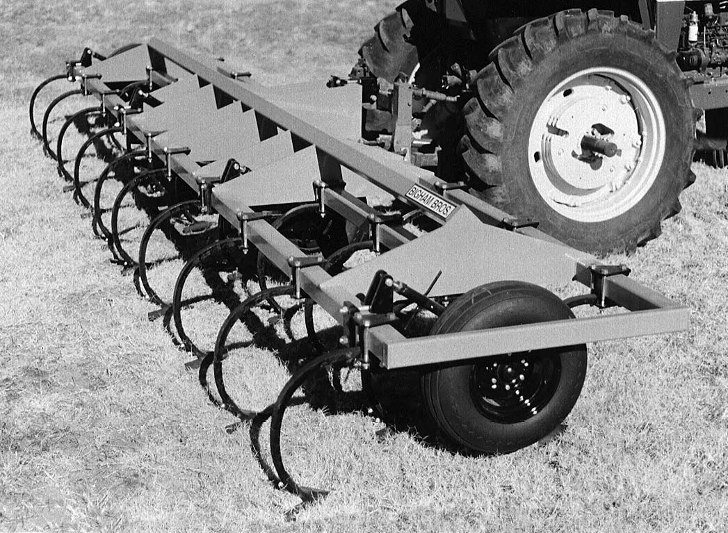 A black and white photo of a tractor with a trailer attached to it