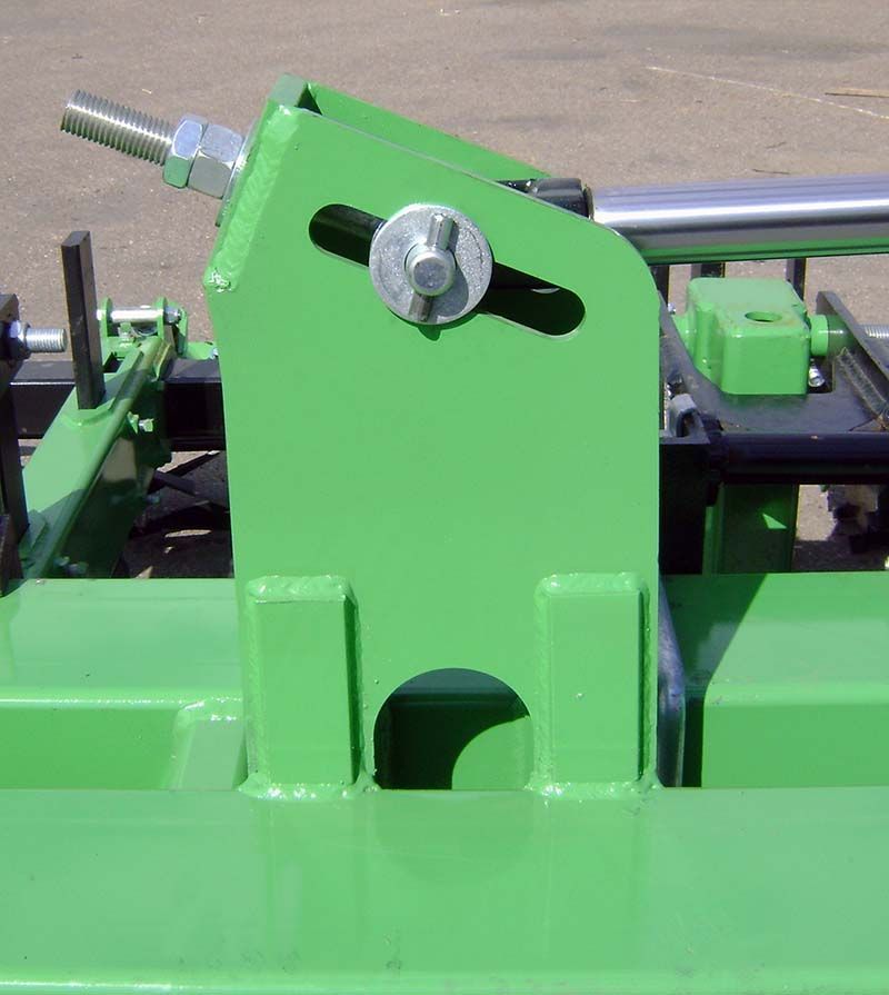 A close up of a green machine with a screw on it