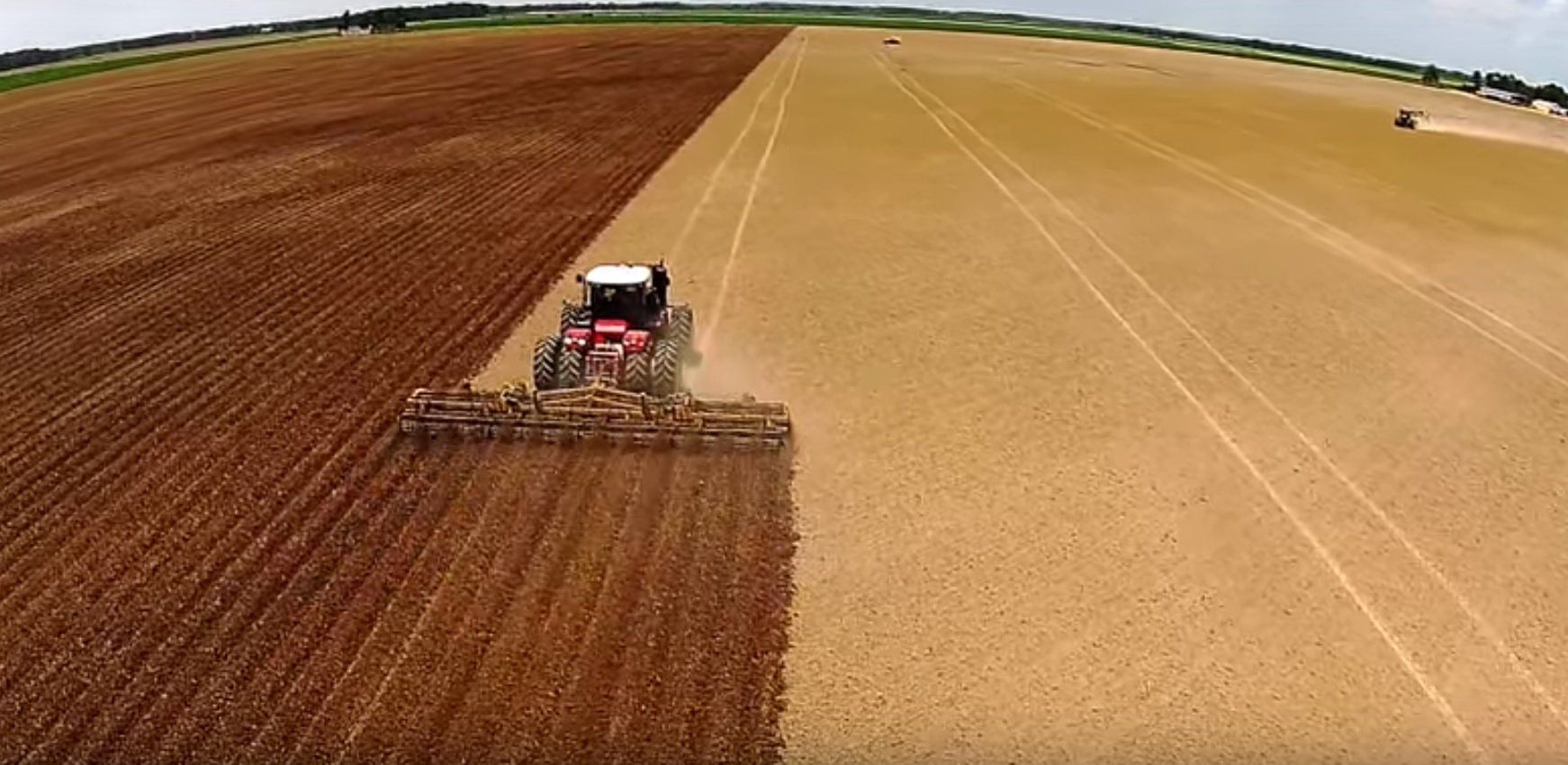 An aerial view of a tractor plowing a field.