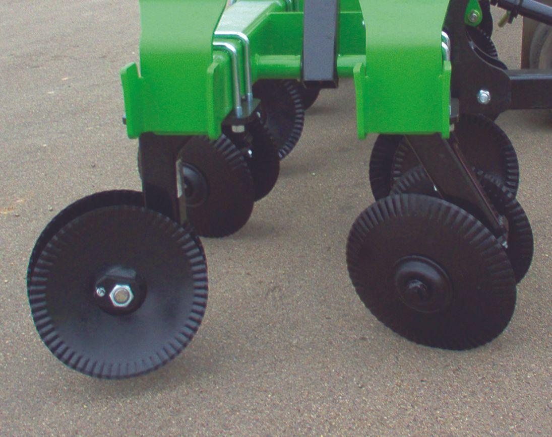 A green tractor with black wheels is parked on the ground
