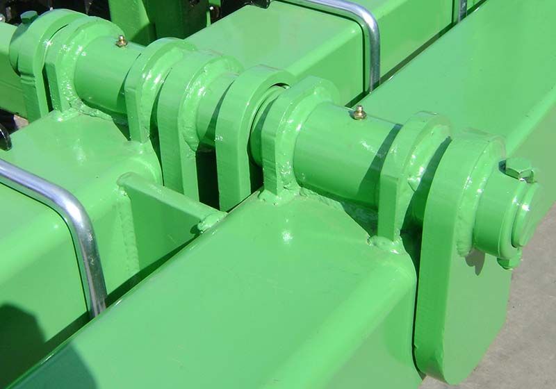 A close up of a green metal structure on a concrete surface.