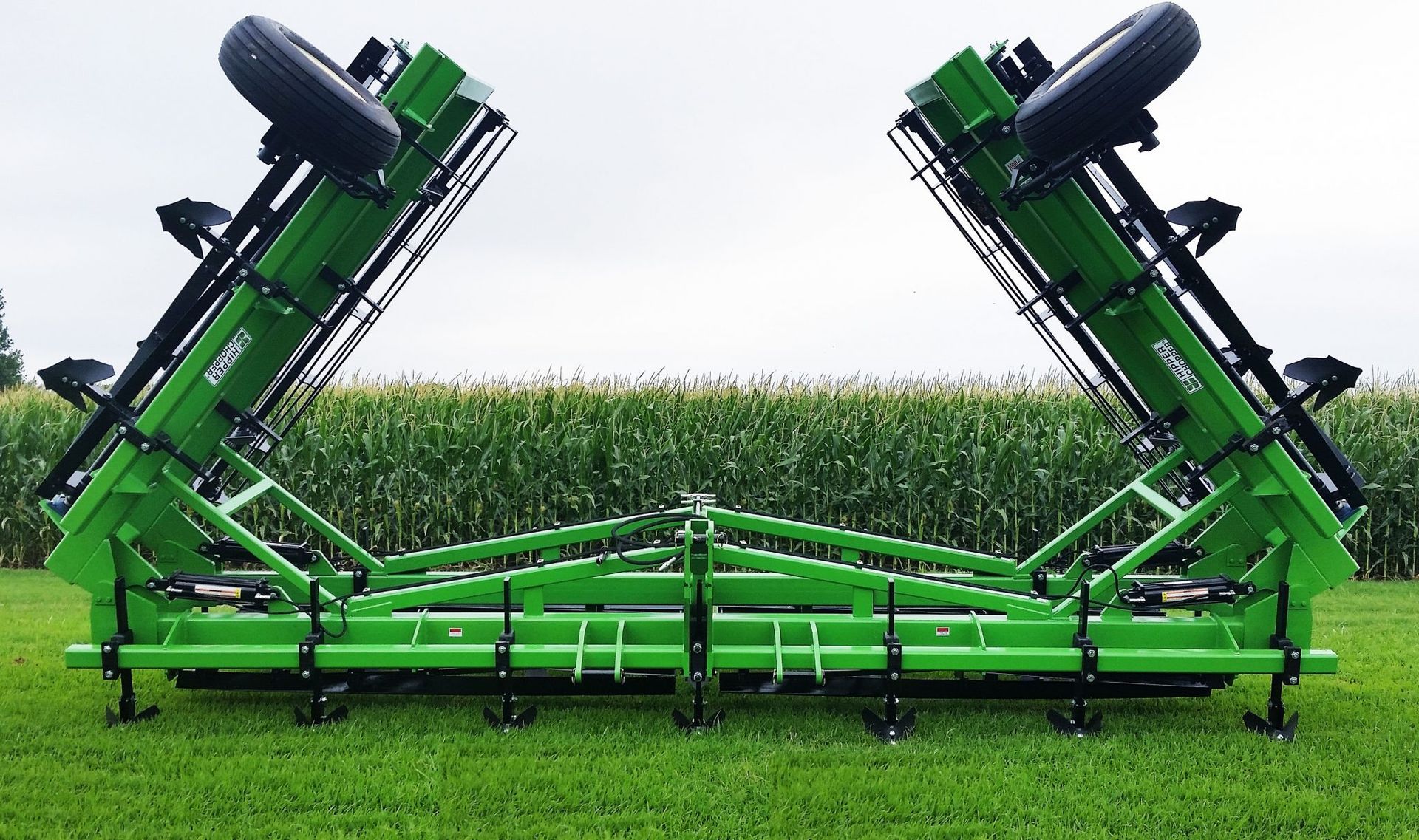 A green tractor is sitting on top of a lush green field.