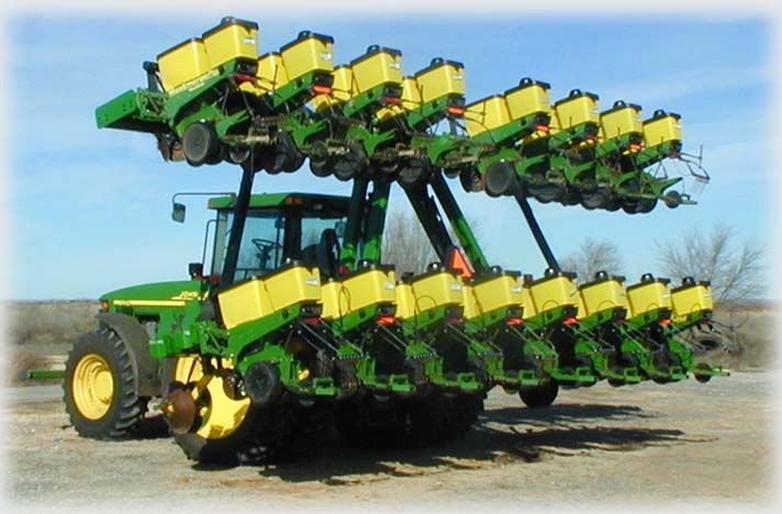A john deere tractor with a row of yellow planters attached to it