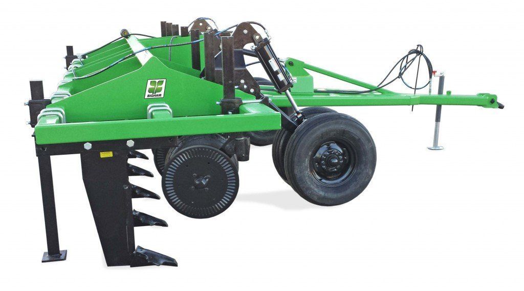 A green and black tractor with a trailer attached to it.