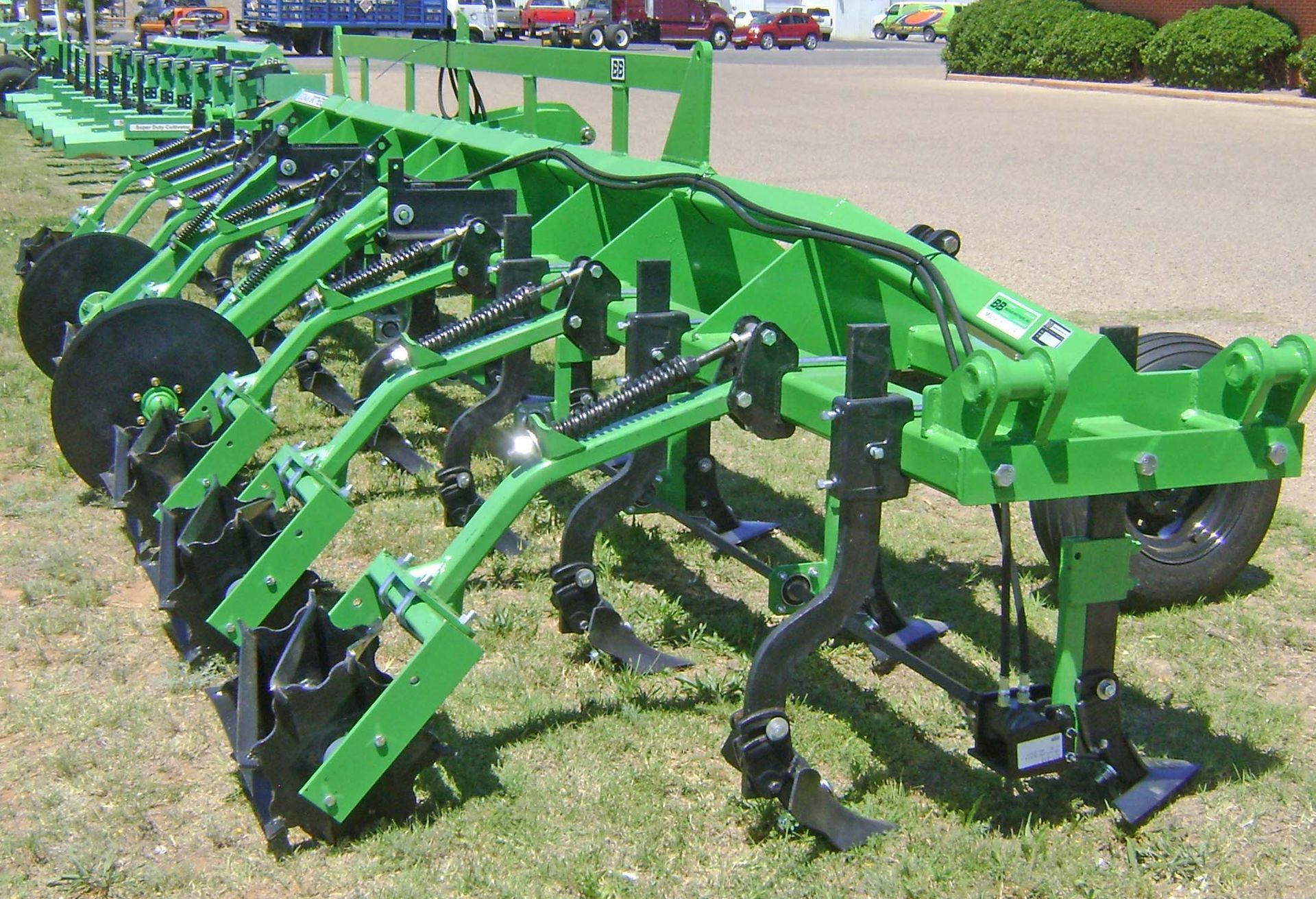 A green and black tractor is parked in the grass