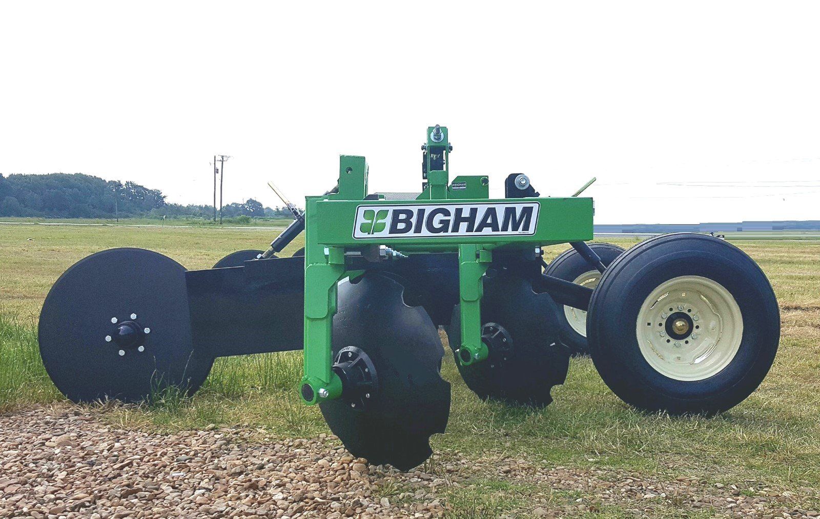 A bigham tractor is parked in a grassy field