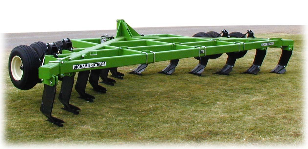 A green and black tractor is sitting in the grass