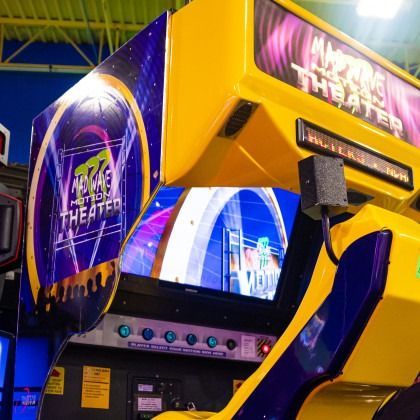 Yellow and purple arcade theater cabinet with glowing screen in a game center