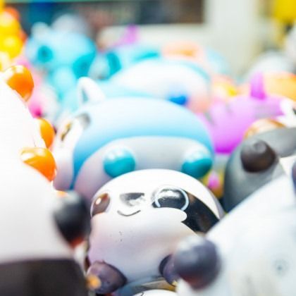 Colorful rows of small panda figurines with white, blue, purple, and orange accents