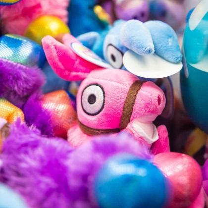 Colorful plush fish toys in pink, blue, and purple piled together