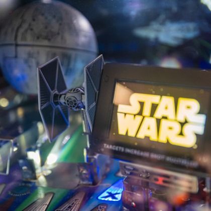 Star Wars display with TIE fighter model and glowing yellow logo in a sci-fi scene