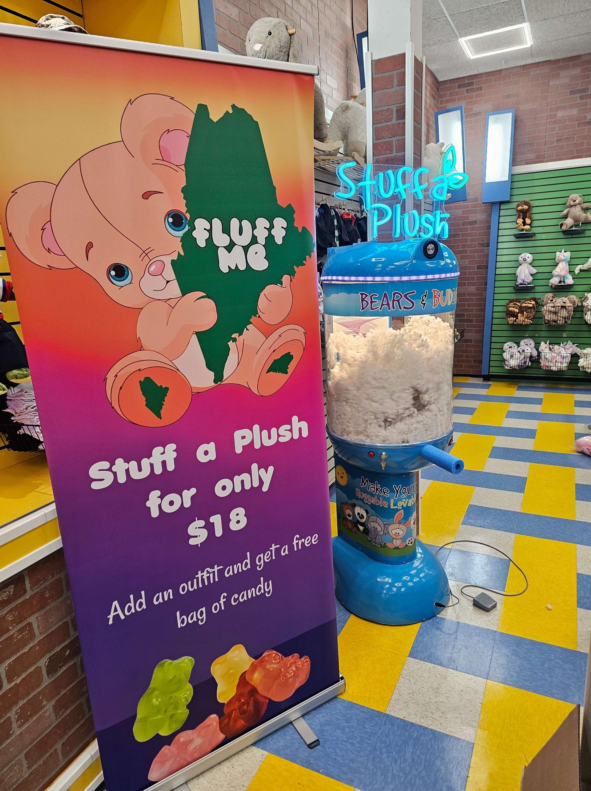 Stuff a Plush sign beside a colorful toy dispenser in a store, with a tiled floor and plush toys in the background