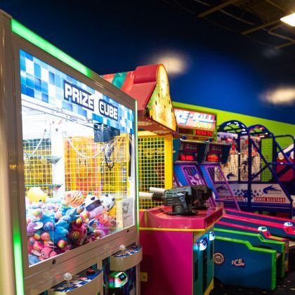 Colorful arcade prize game and other games in a bright amusement center
