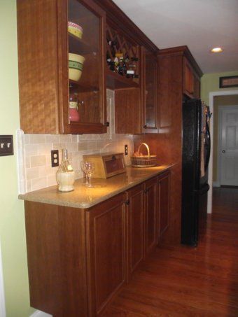 Kitchen with wood cabinets, granite countertop, and hardwood floor in warm lighting