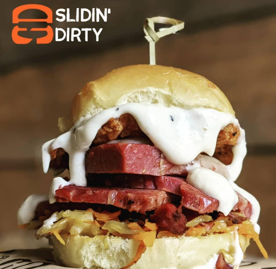 A towering slider sandwich with corned beef, fried topping, and white sauce, from Slidin' Dirty.