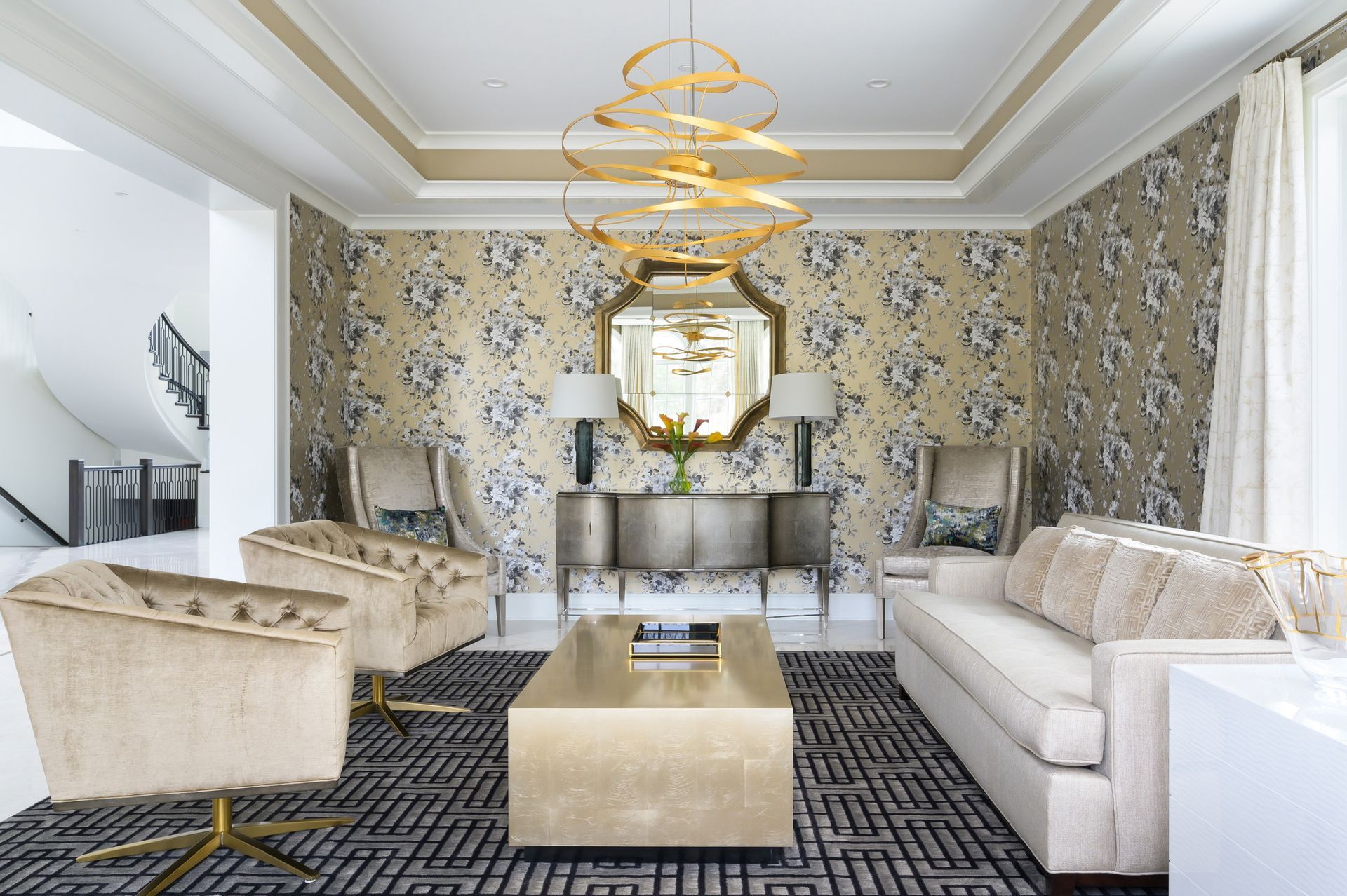 A living room with a couch , chairs , a coffee table and a chandelier.