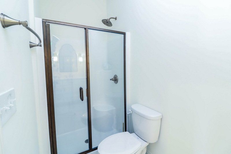 A bathroom with a toilet and a shower stall.