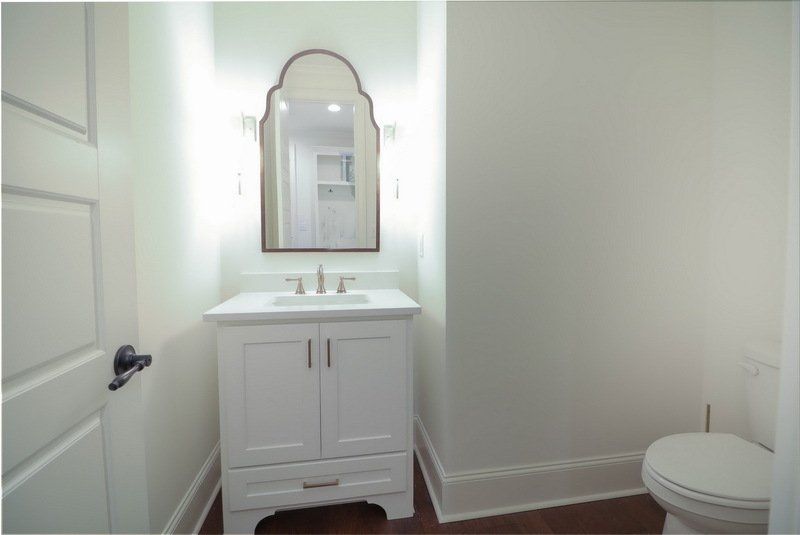 A bathroom with a toilet a sink and a mirror