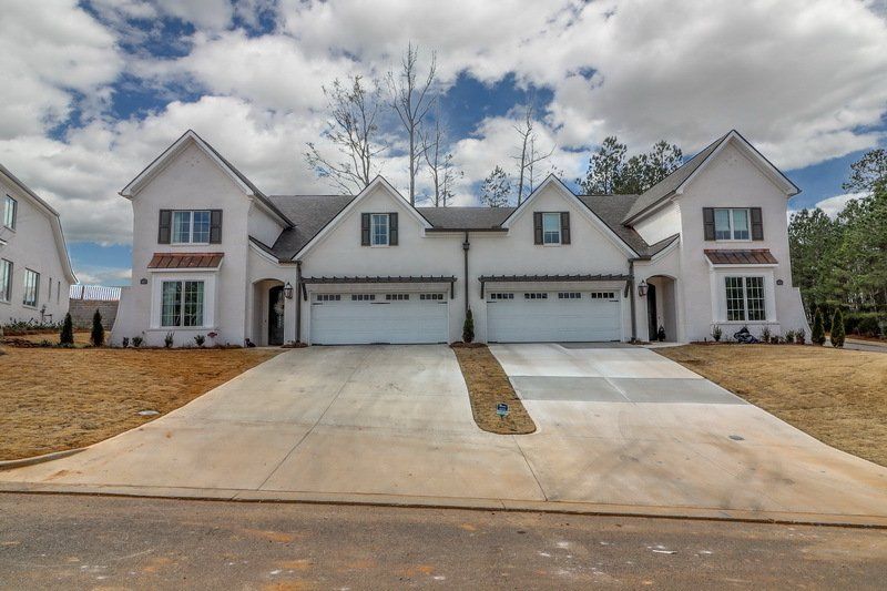 A white house with two garages and a driveway