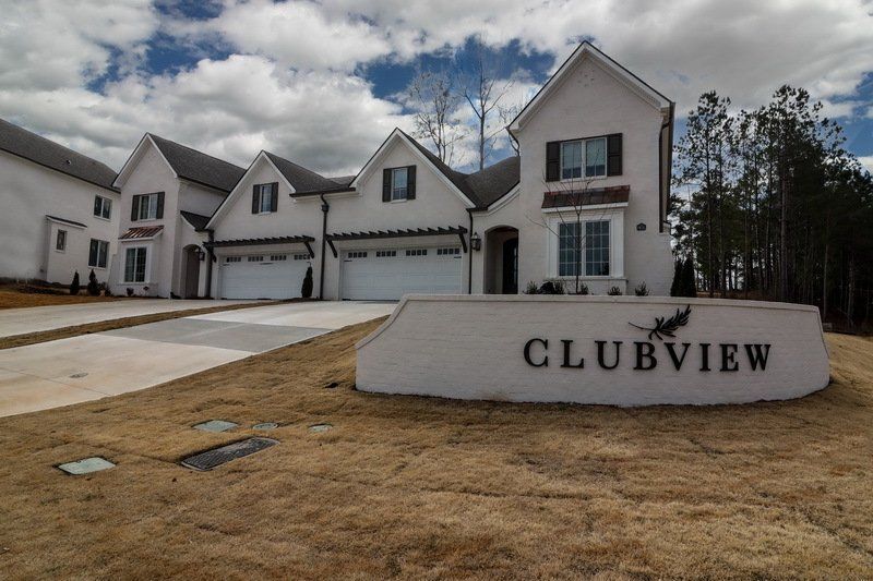 A white house with a sign that says clubview in front of it