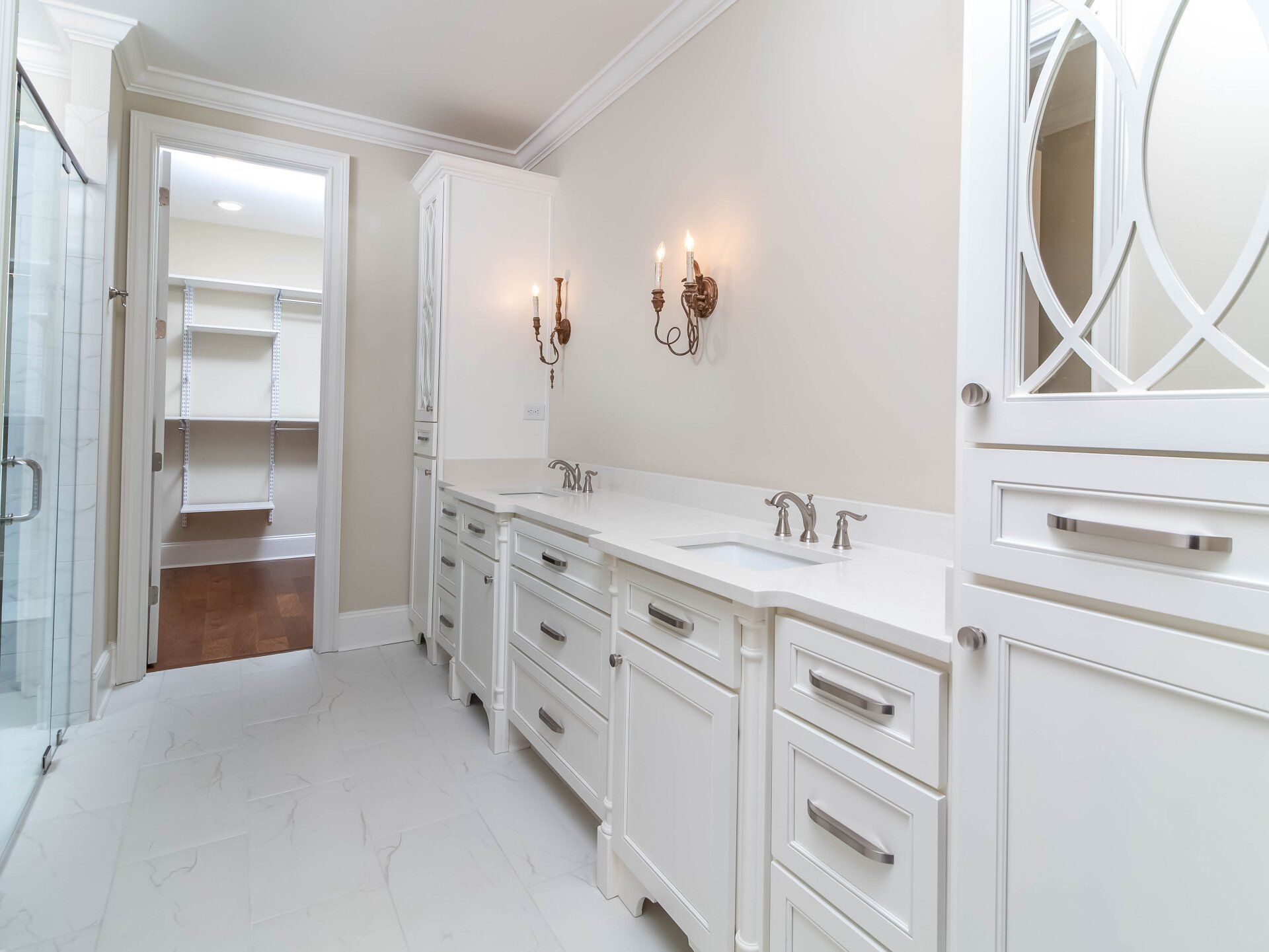 A bathroom with white cabinets , a sink , and a mirror.