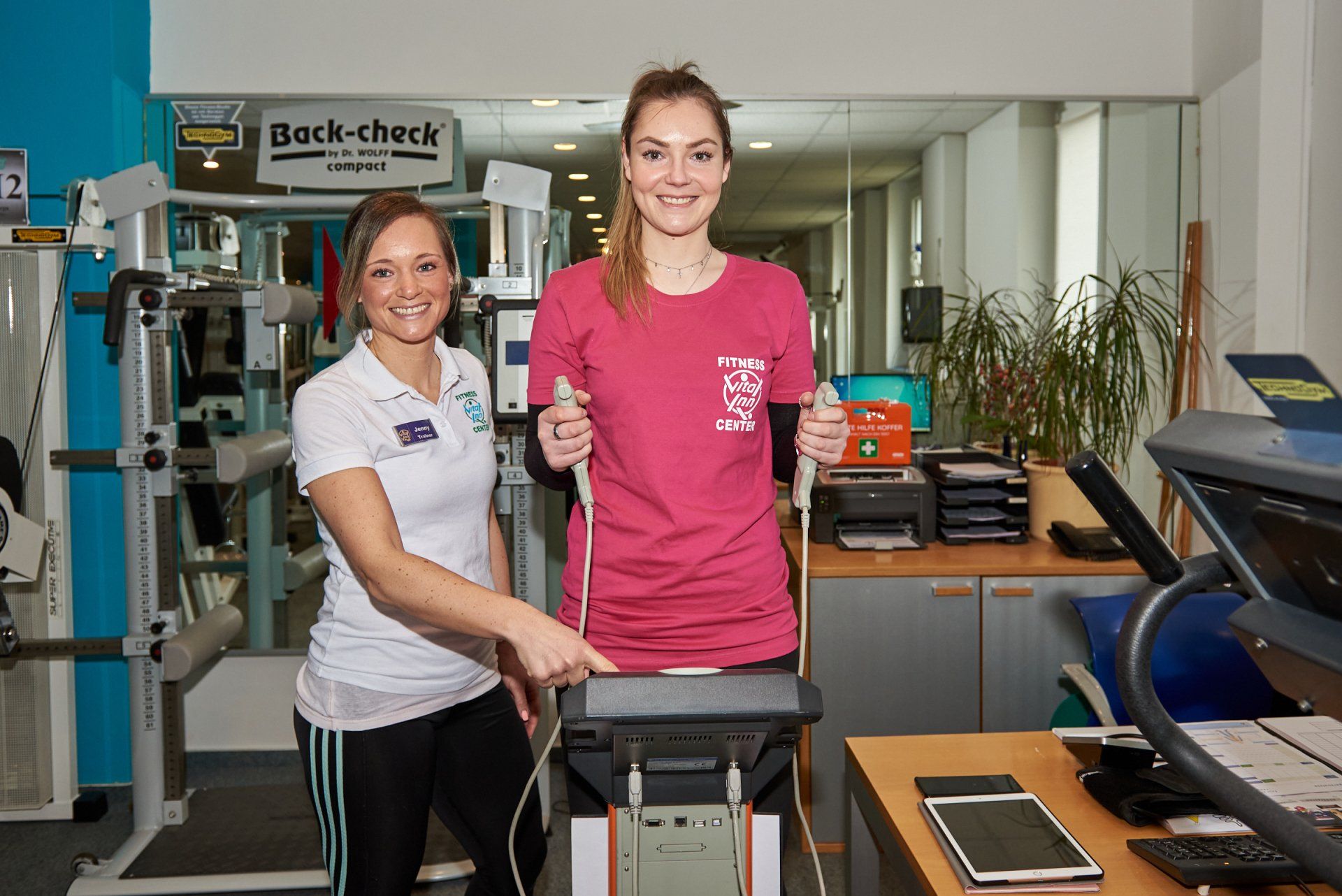 Zwei Frauen stehen nebeneinander in einem Fitnessstudio.