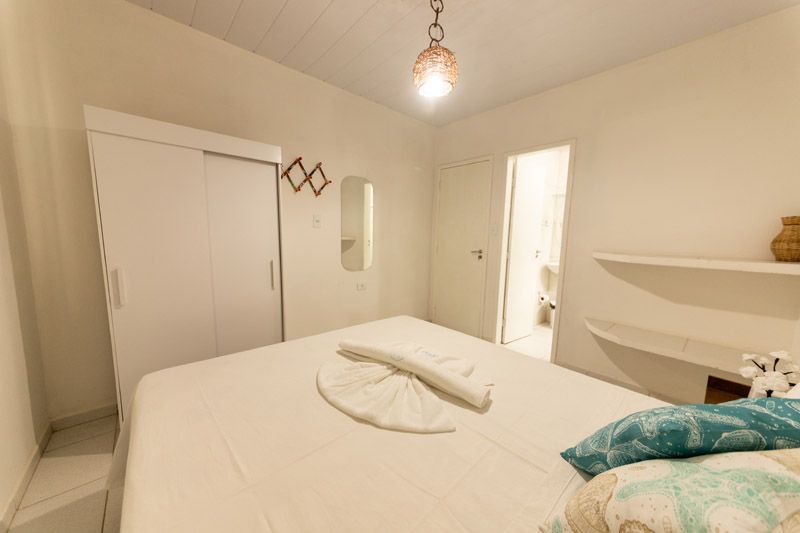 Um quarto luminoso com uma cama branca