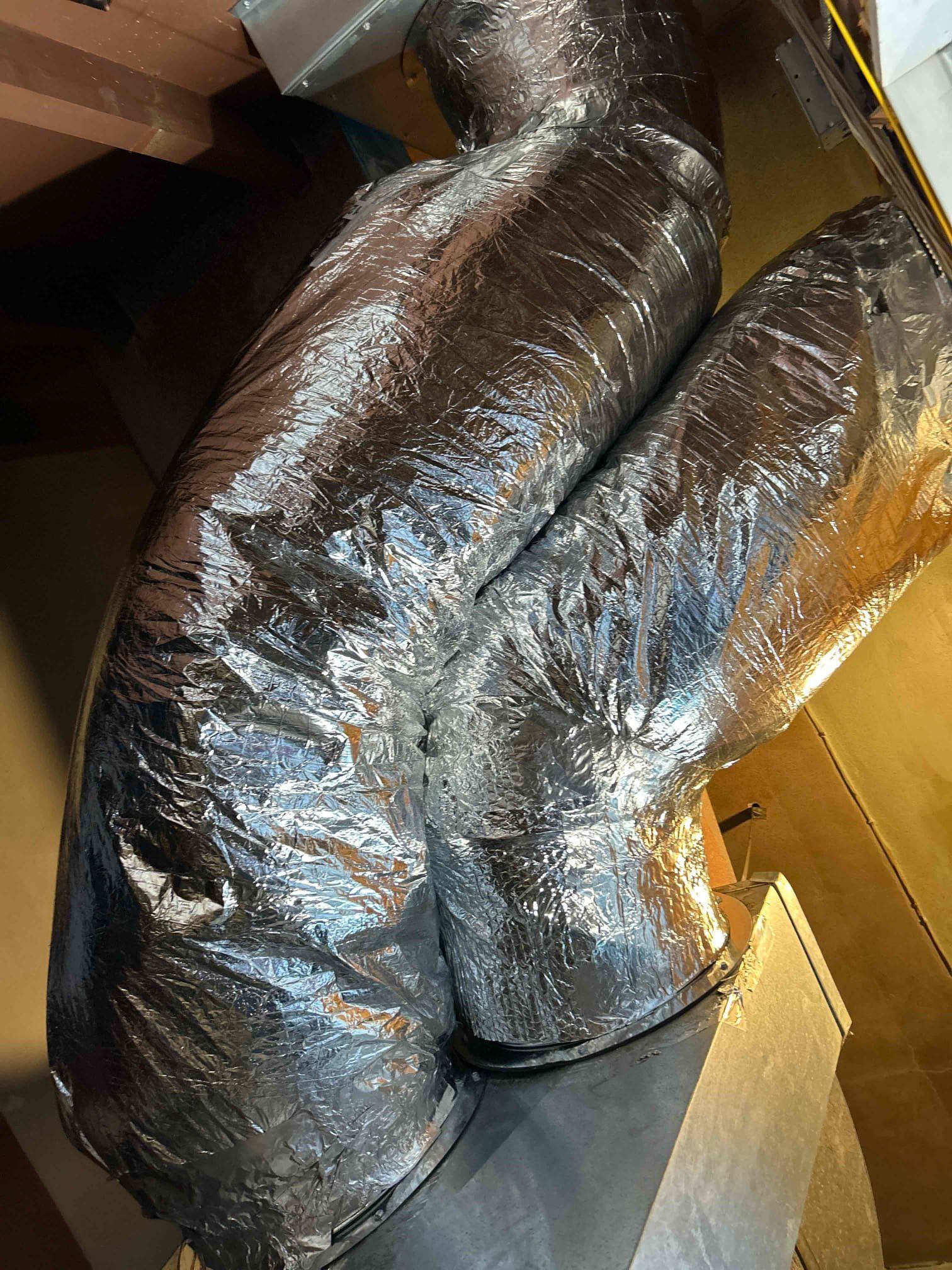 Black insulated HVAC ducting inside a ceiling space