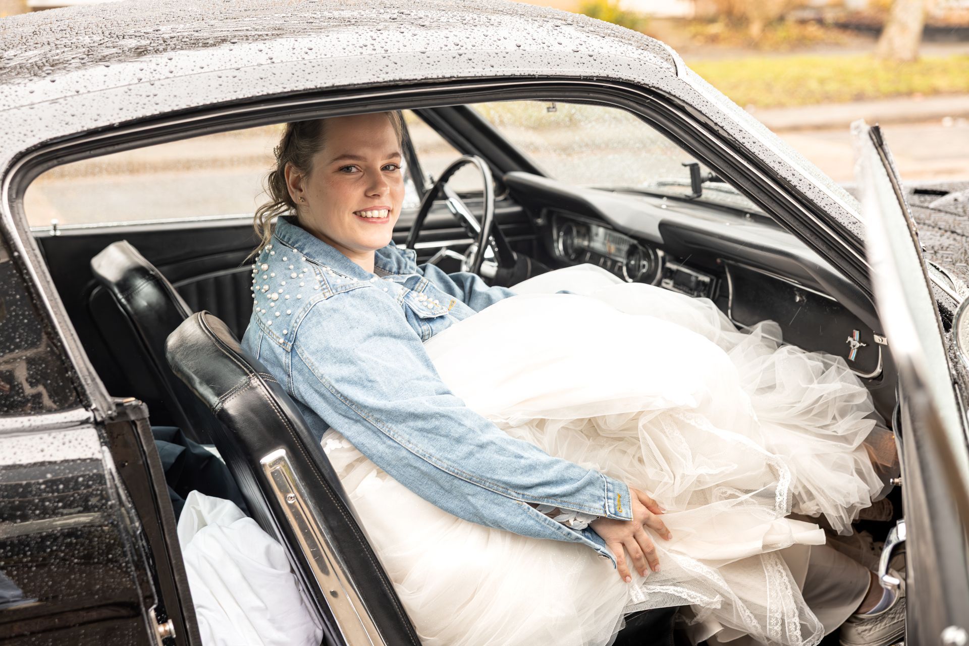 Man zittend in een klassieke auto, kijkend uit het raam op een zwart-witfoto. Bruidsfotograaf Voorne Putten.