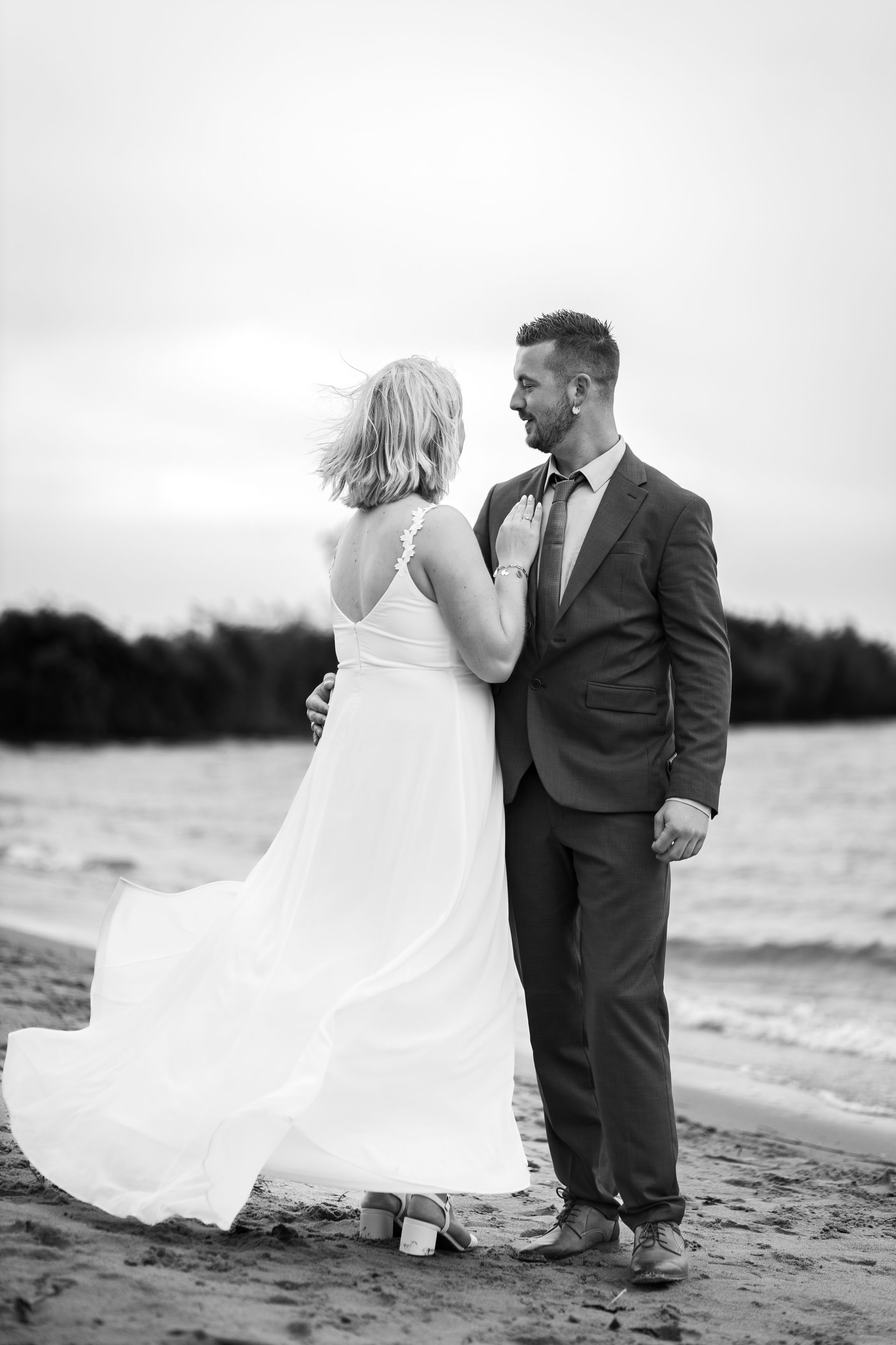 Bruid en bruidegom hand in hand op een strand in zwart-wit Bruidsfotograaf Zuidland.