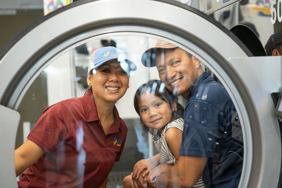The Fresh Laundries family pictured through a washing machine door