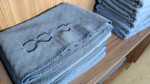 Neatly stacked blue commercial towels prepared by Fresh Laundries