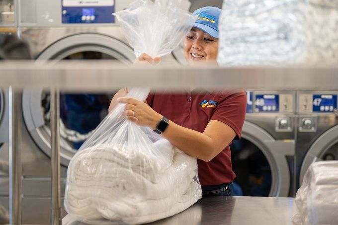 Fresh Laundries staff member packaging clean linens for commercial laundry service