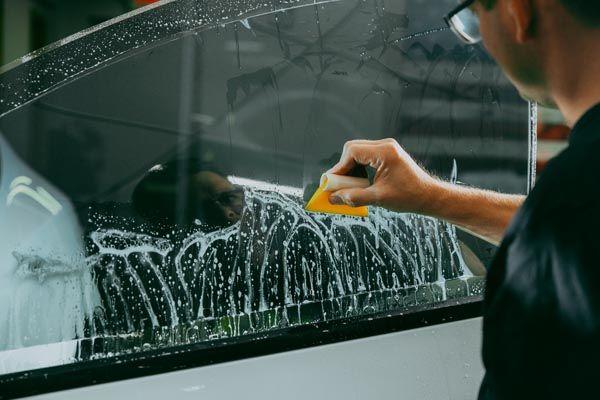White car receiving window tint service.