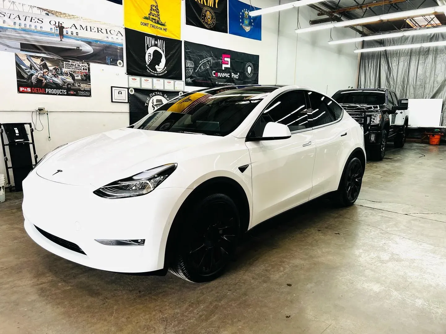 White Tesla with ceramic coating inside a detailing shop.