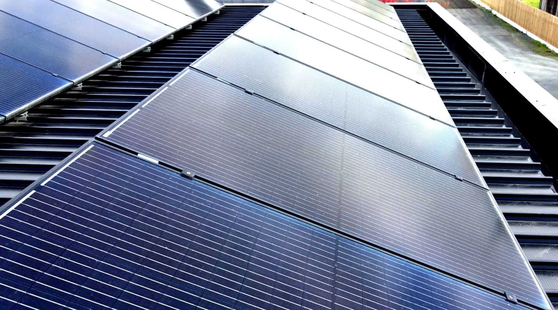 A row of solar panels on the roof of a building