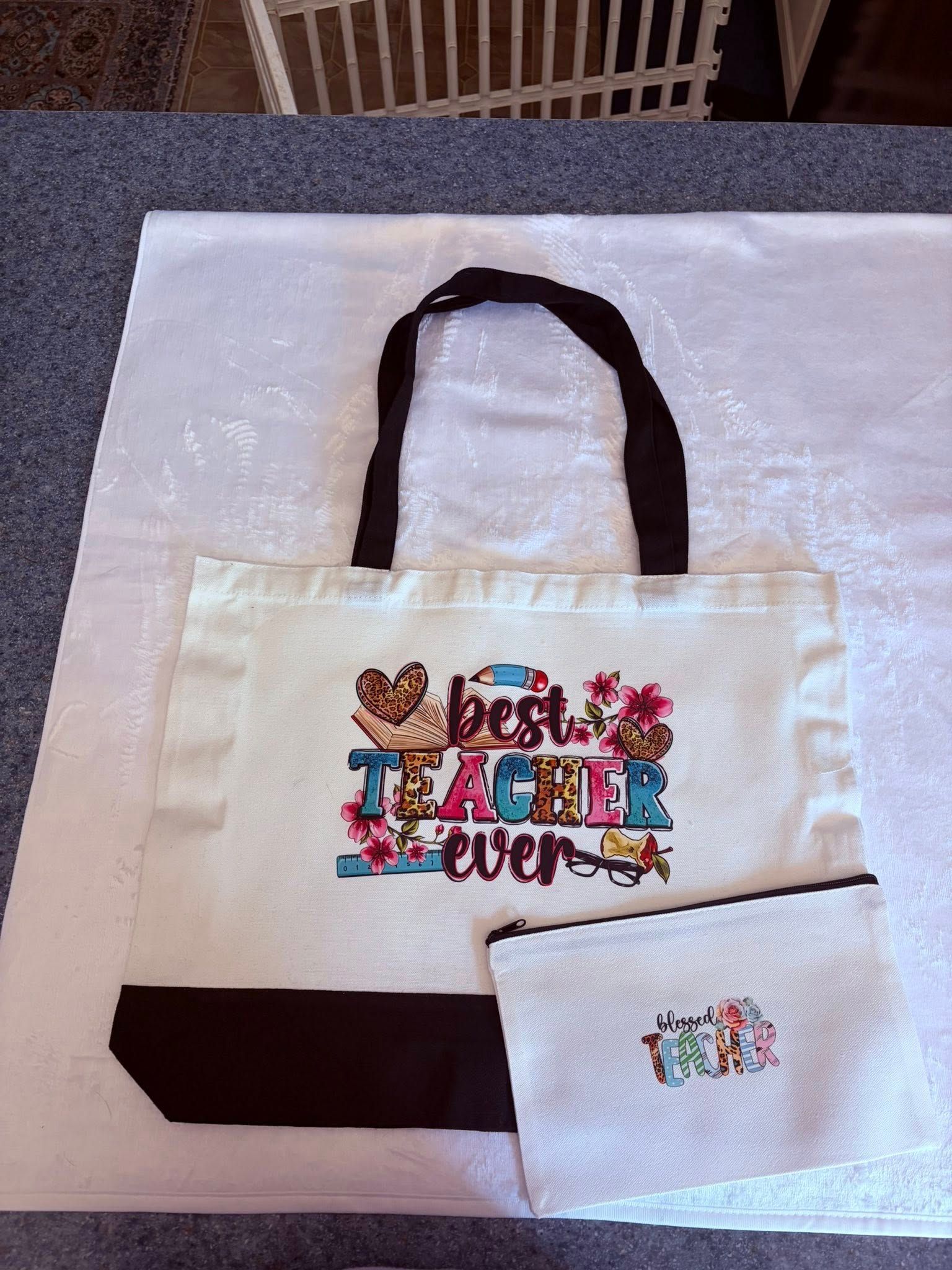 White tote bag with black handles and colorful “Best Teacher Ever” design, plus matching small pouch