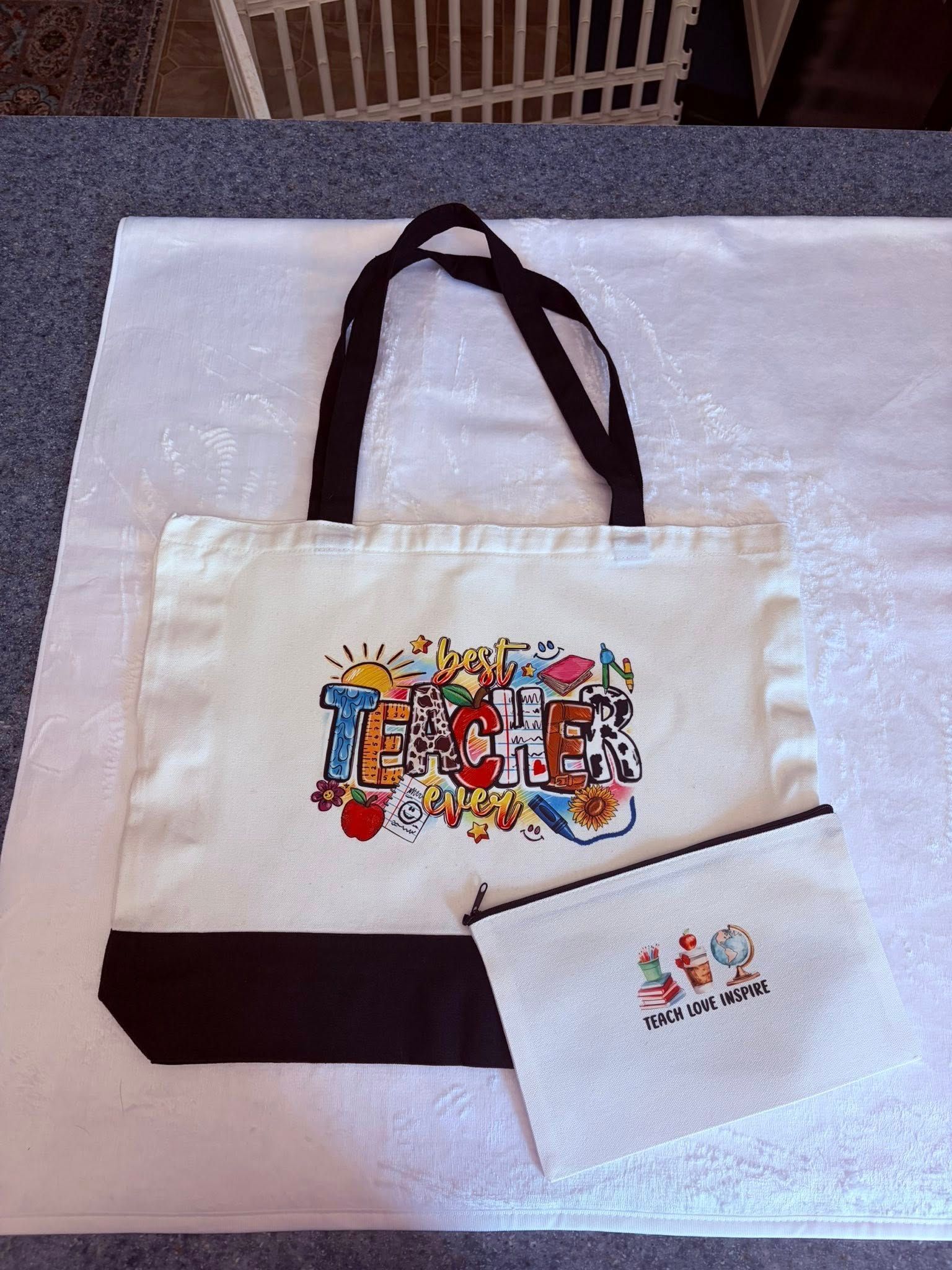 White tote bag with colorful graphic on white surface, with a matching small pouch.