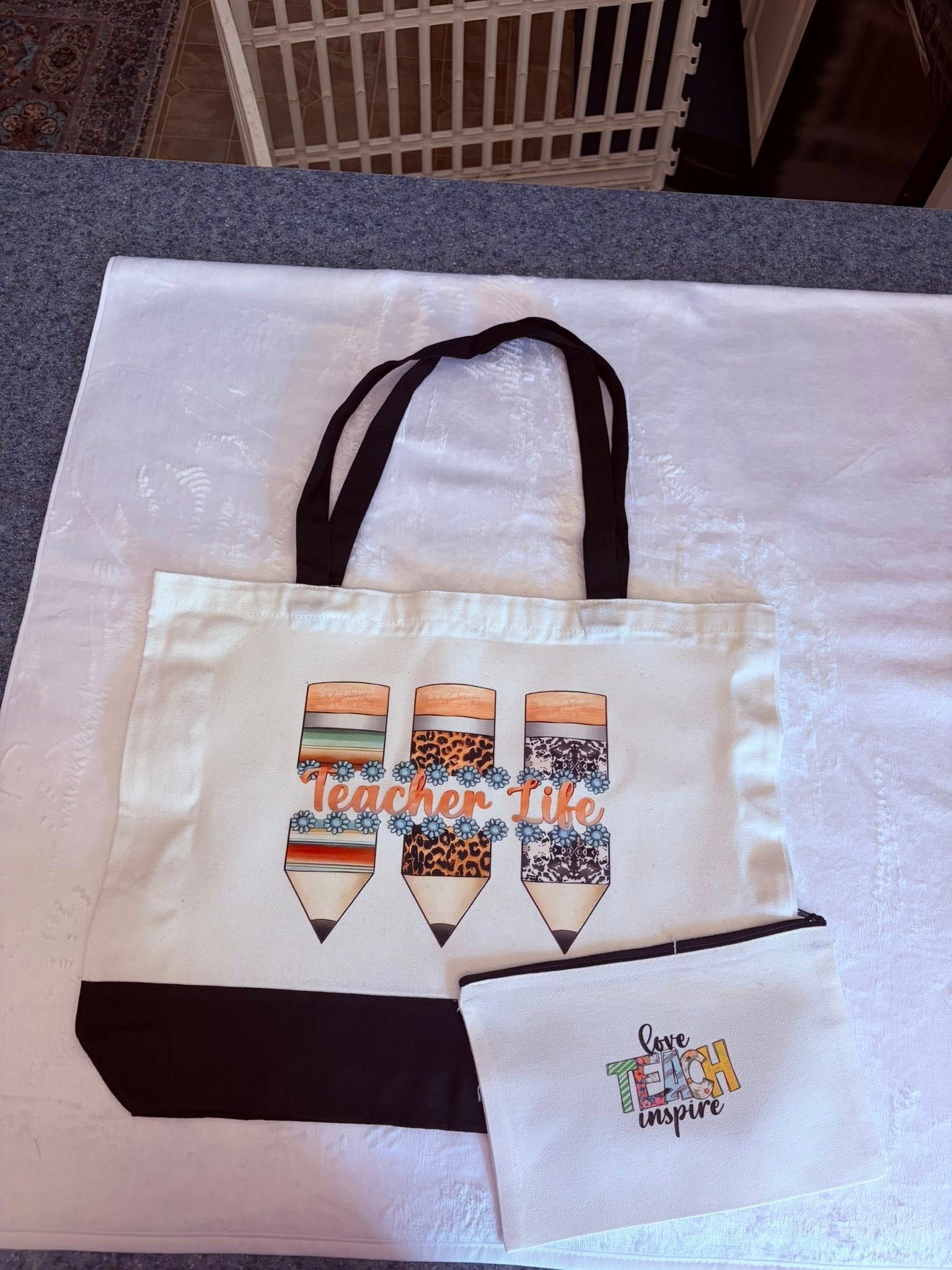 White tote bag with brown handles and colorful printed bottles, plus a small white pouch on a table.